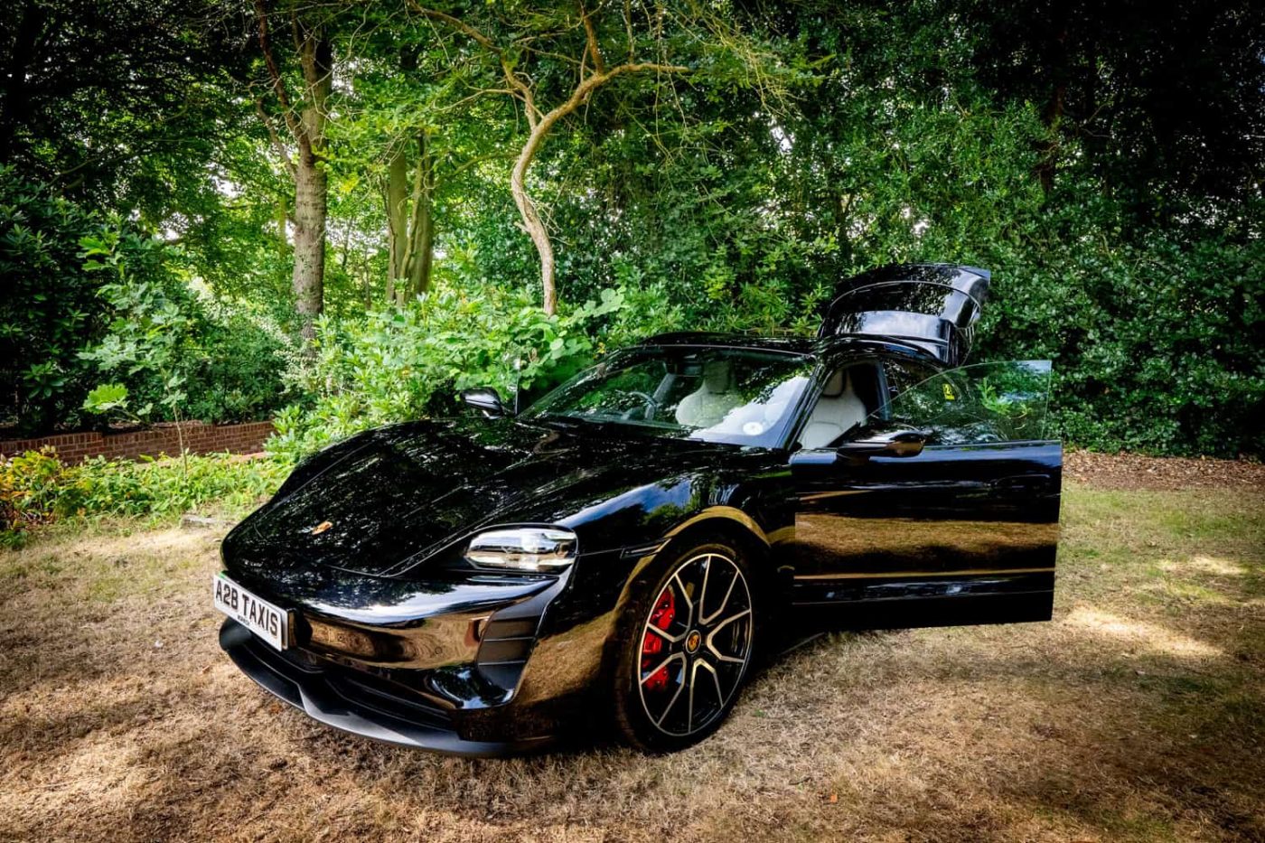 Porsche Taycan 4S with driver door open showing cream leather interior