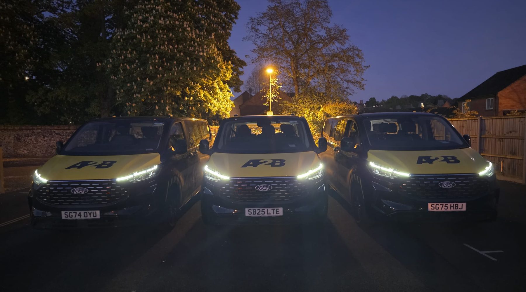 Minibus Taxis in Norwich 1 Three A2B Taxis minibuses lined up at night in Norwich